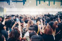 Grupo de personas con el móvil en alto durante un evento